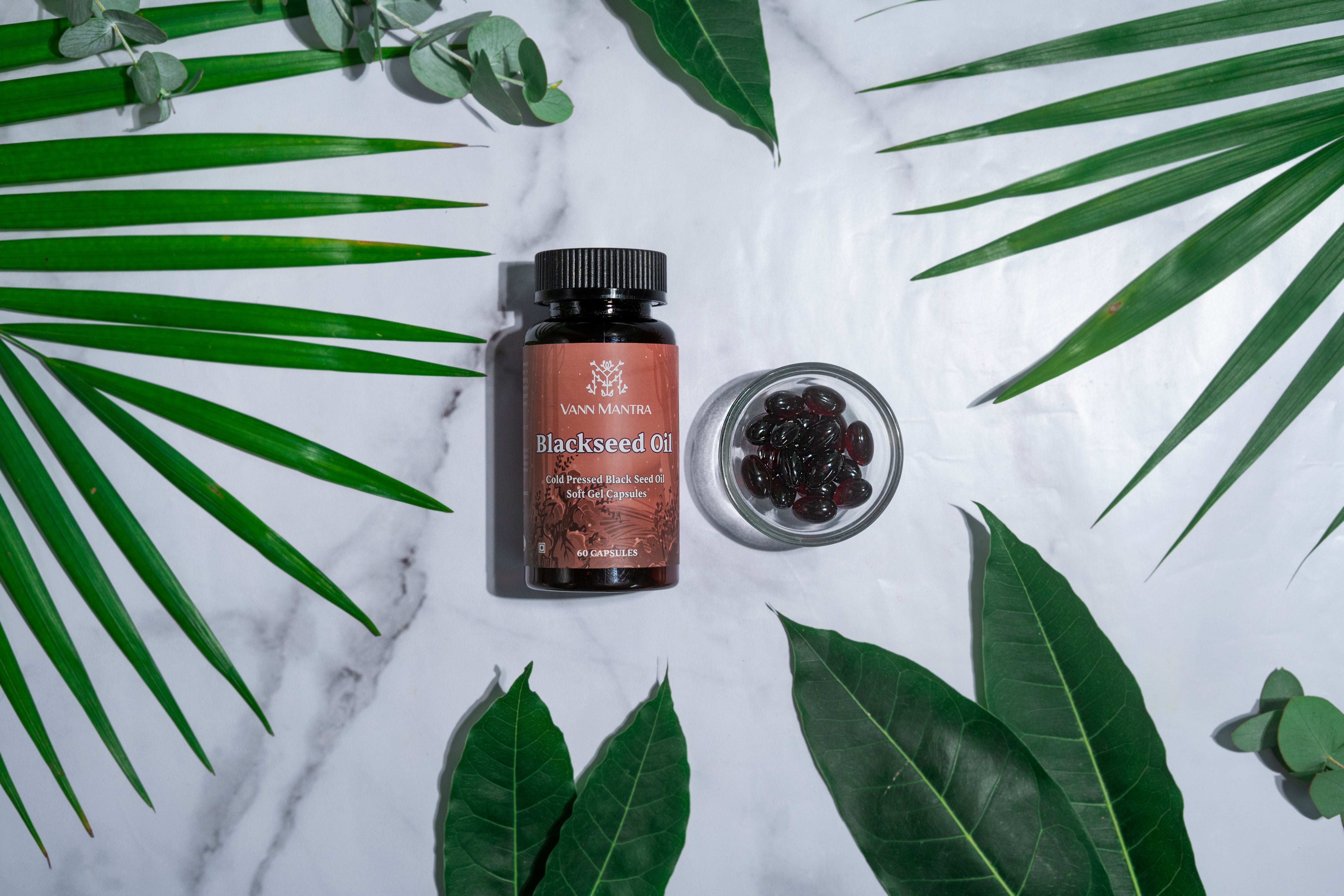 Blackseed oil Capsule on a backdrop with plants