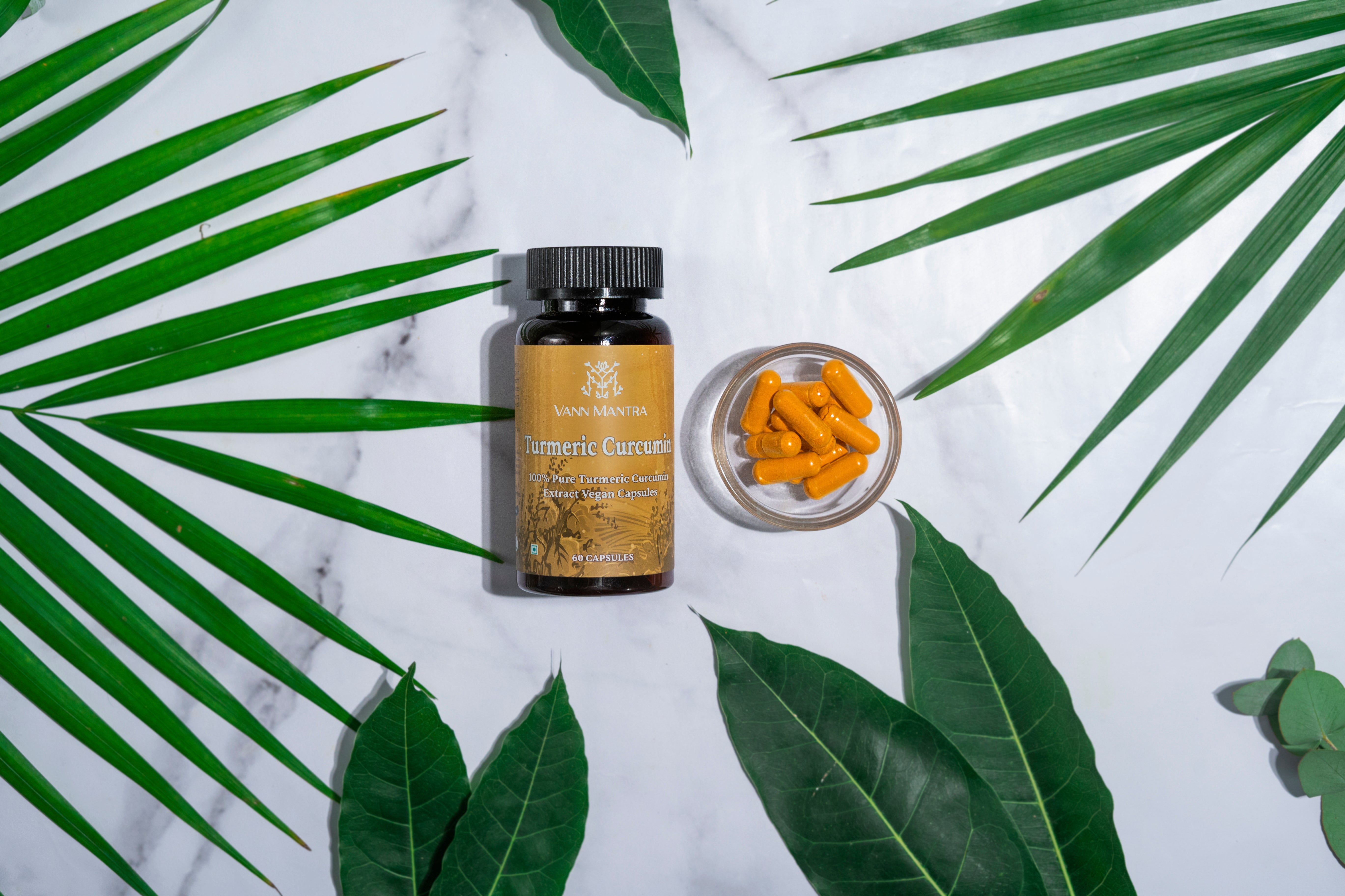 Turmeric Curcumin Capsules on a backdrop with plants.