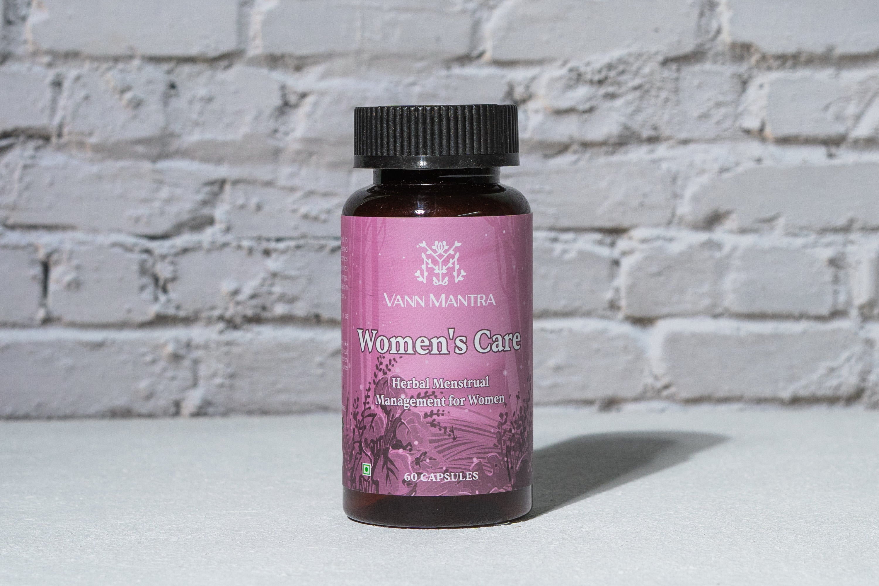 Women's Care Capsules in front of a brick wall
