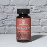 Blackseed Oil Capsules in front of a brick wall