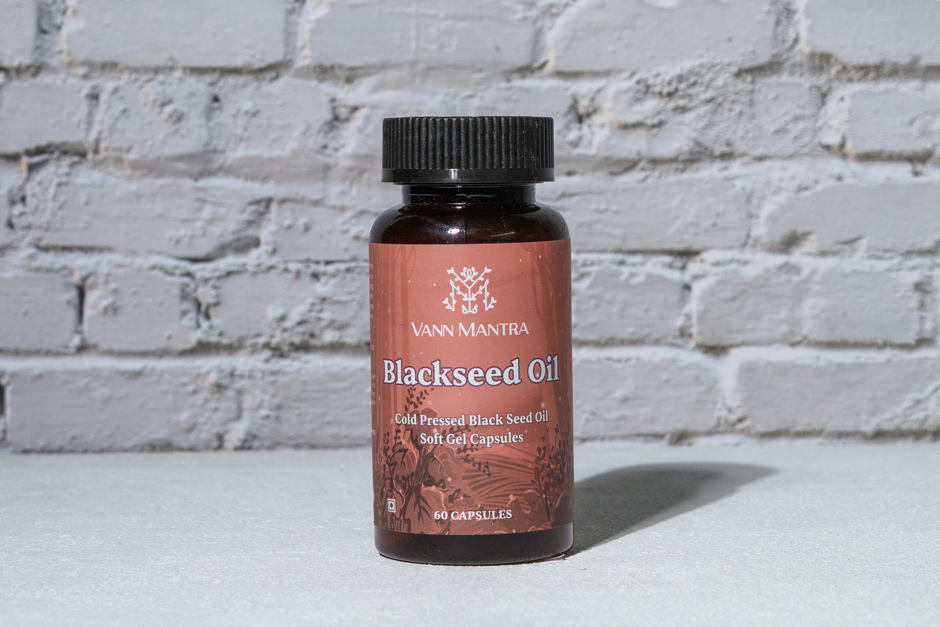 Blackseed Oil Capsules in front of a brick wall