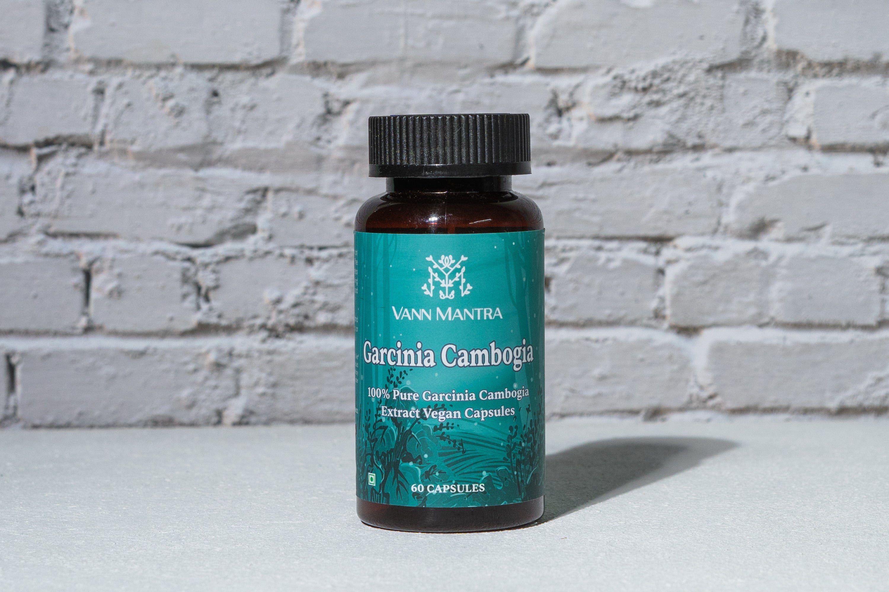 Garcinia Cambogia Capsule in front of a brick wall 