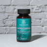 Garcinia Cambogia Capsule in front of a brick wall 