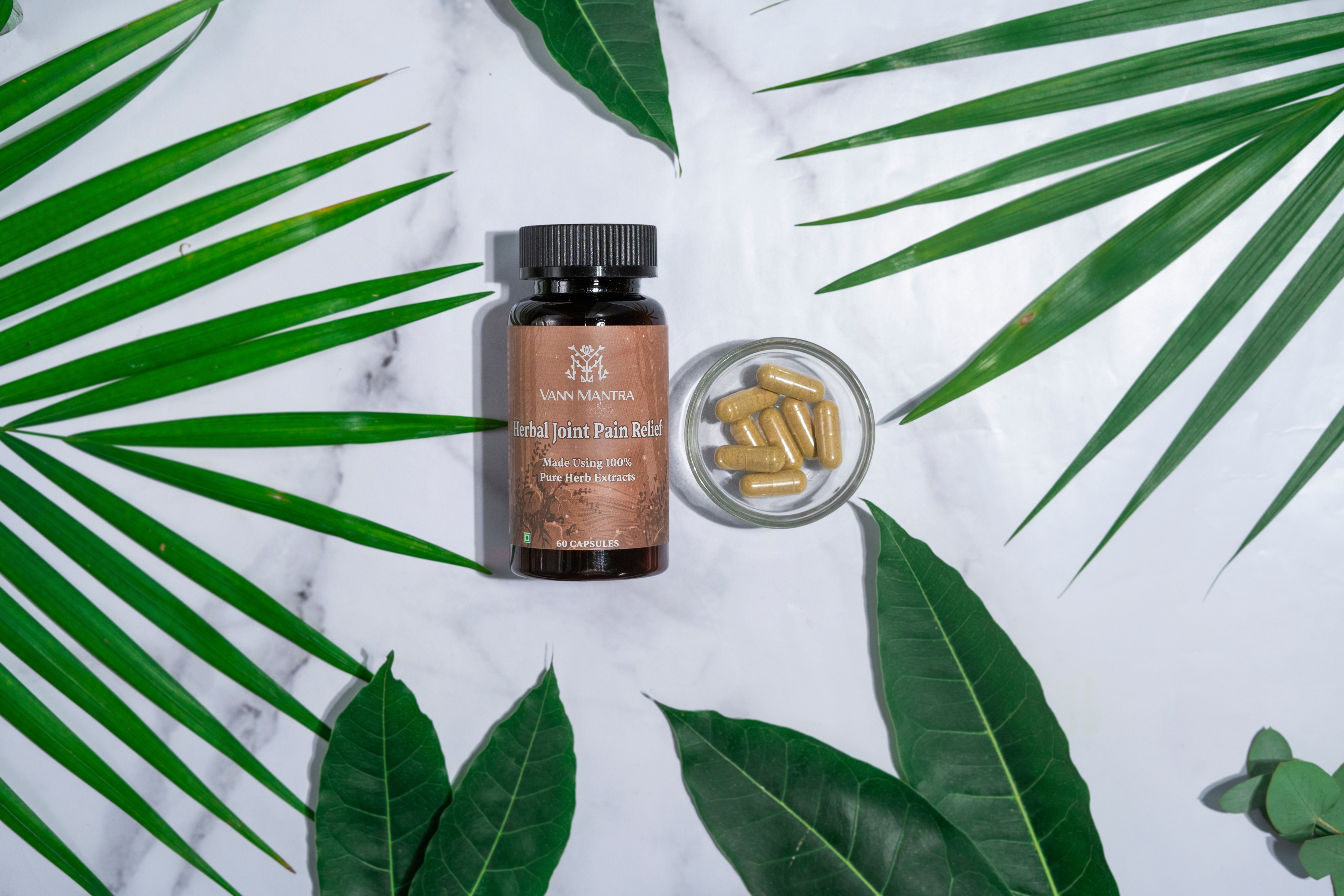 Herbal Joint Pain Relief Capsules on a backdrop with plants. 