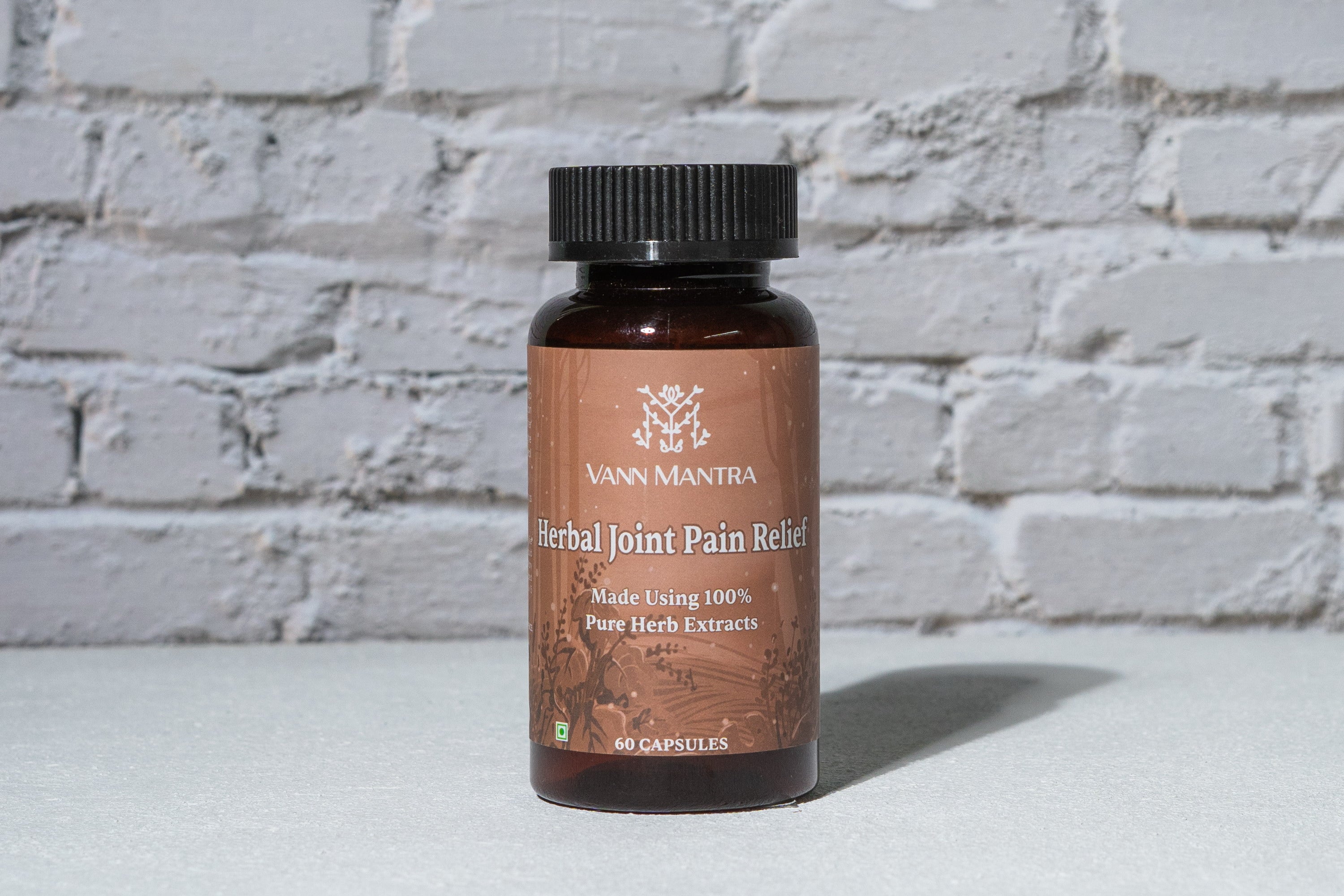 Herbal Joint Pain Relief Capsules in front of a brick wall 