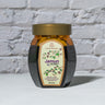 Jar of Jamun Honey in front of a brick wall 