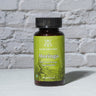 Moringa Capsules in front of a brick wall 