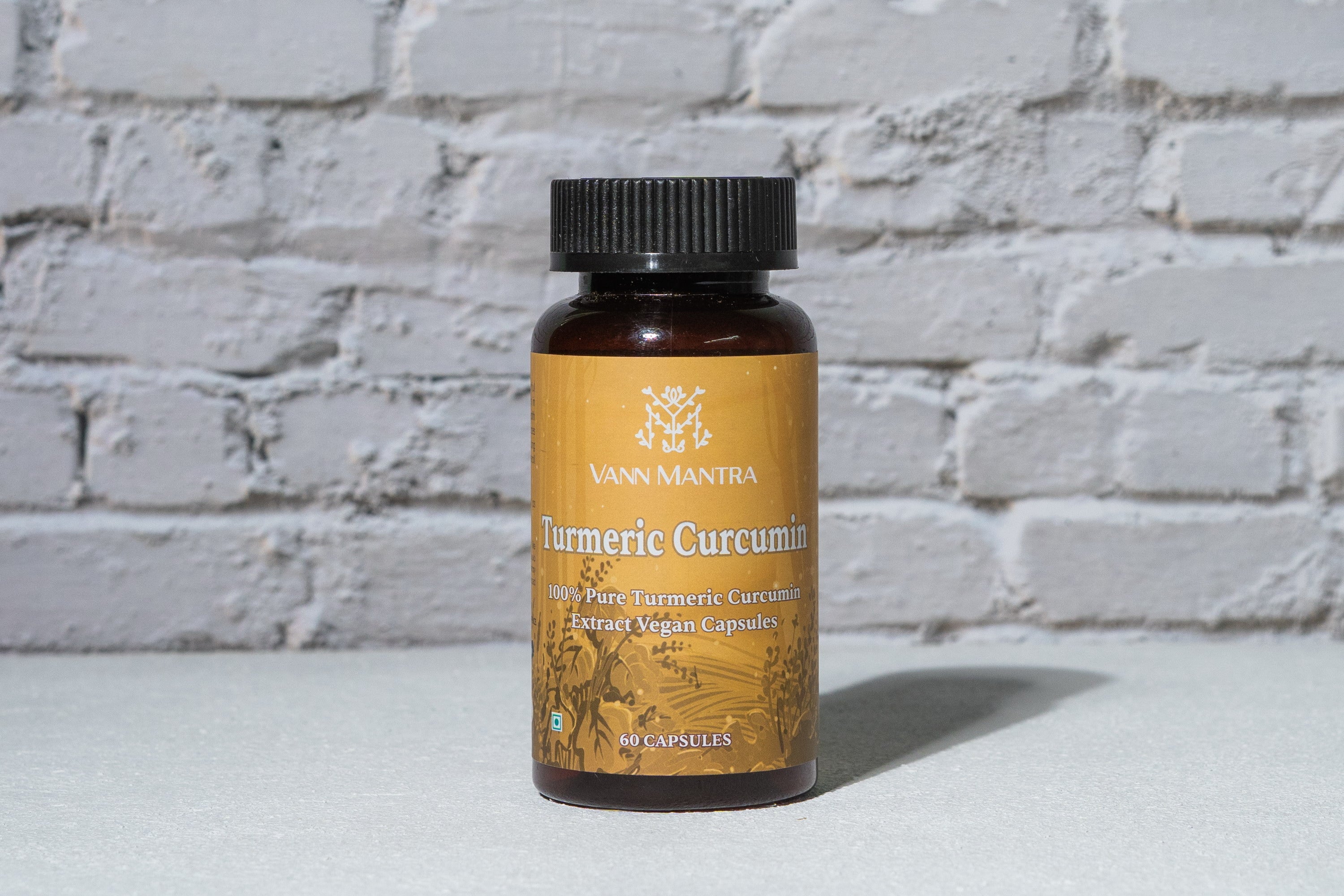 Turmeric Curcumin Capsules in front of a brick wall 