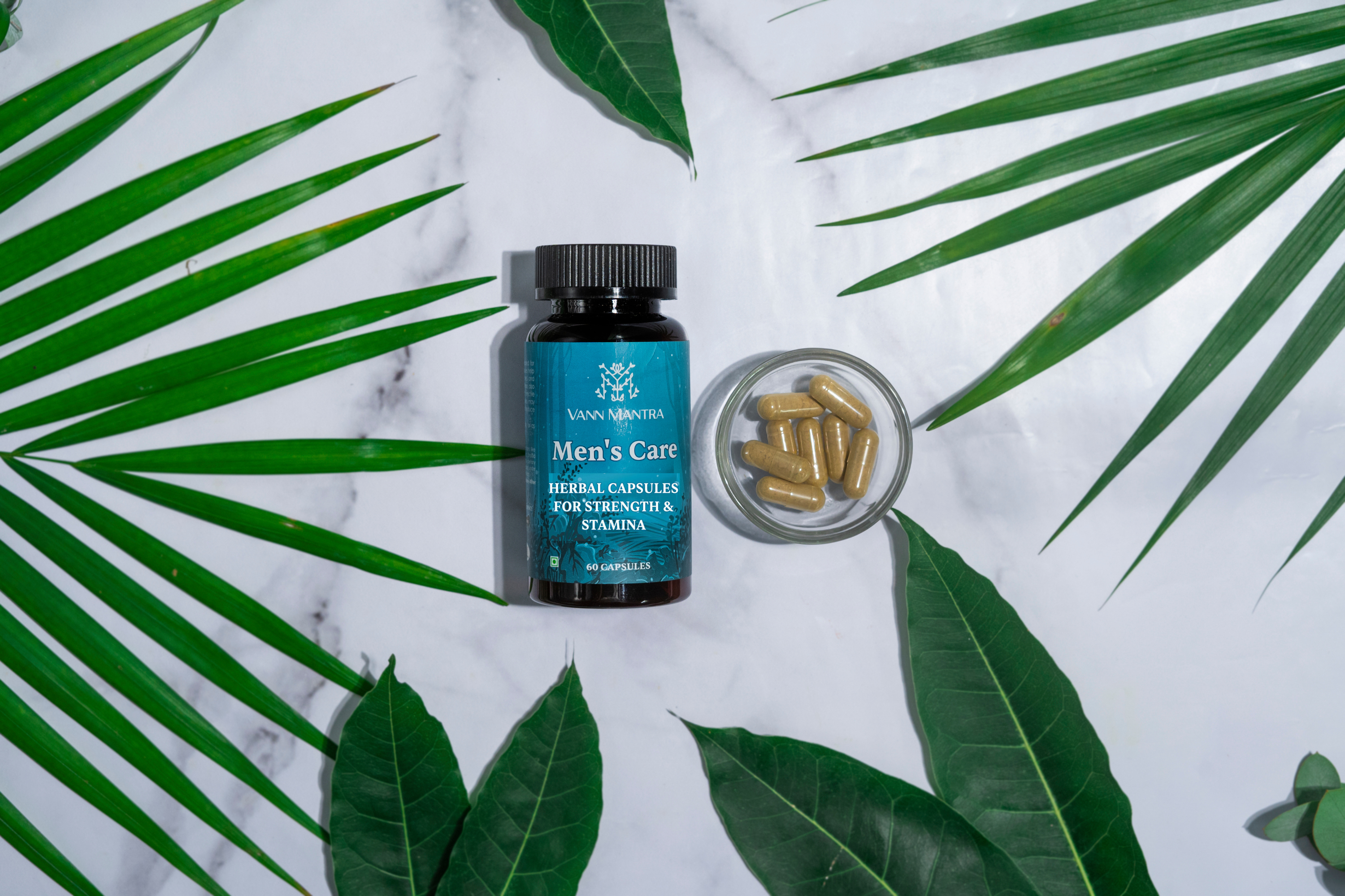 Men's Care Capsules on a backdrop with plants. 