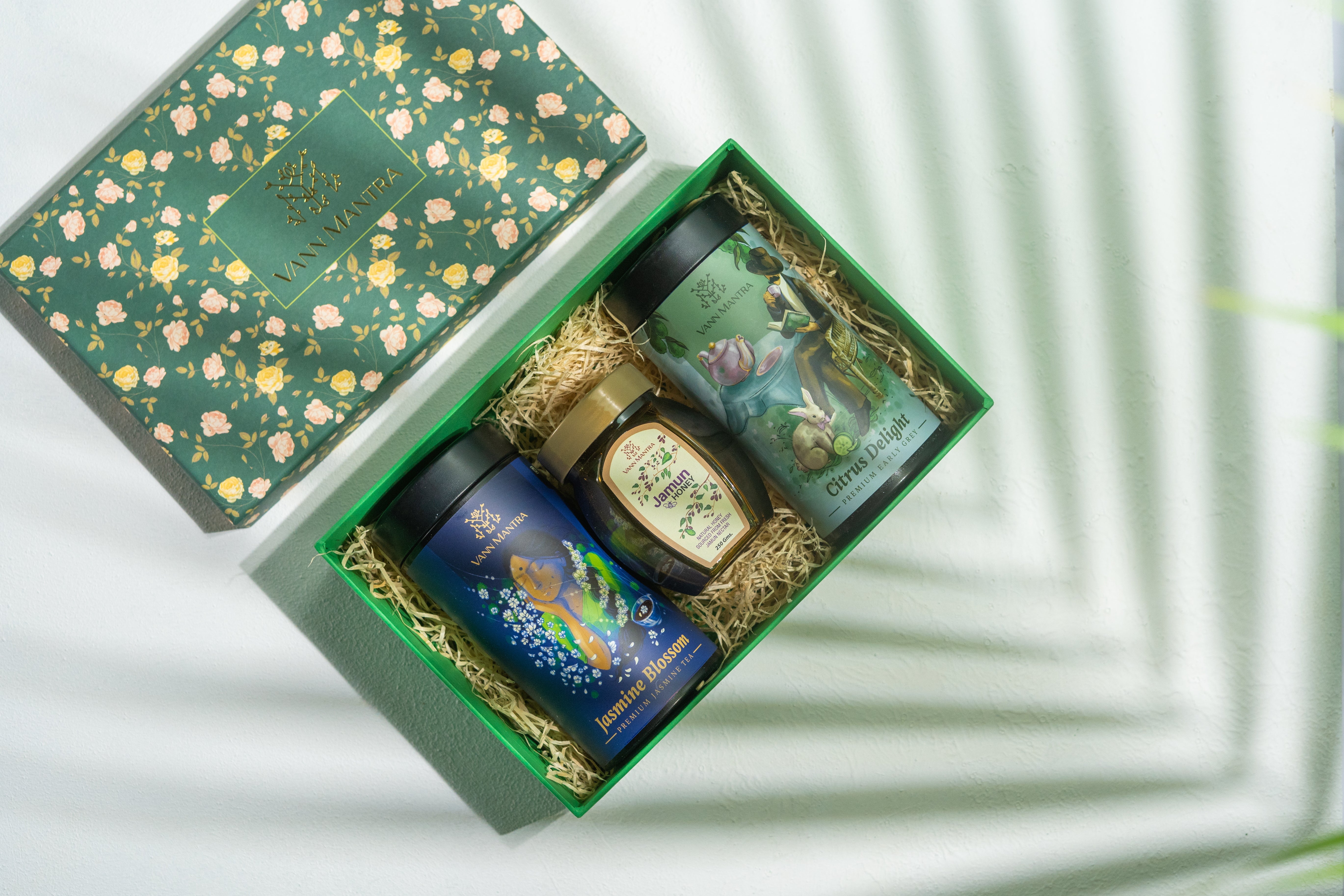 Box Of Pleasing Aroma (Jasmine Blossom, Citrus Delight, Jamun Honey) on a backdrop with plants