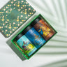 Box Of Morning - Afternoon - Night (Weight Warrior, Happy Belly, Calming Monk) on a backdrop with plants